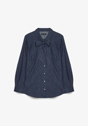 Donkerblauwe denim blouse met lange mouwen, vooraan parelknopen en een strikbandkraag, plat uitgestald op een witte achtergrond.