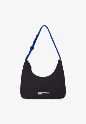 Černá nylonová taška přes rameno s zakřiveným tvarem, modrým lanovým popruhem a stříbrným logem na přední straně. Zapínání na zip na vrchu.
