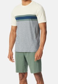 T-shirt à manches courtes en crème, gris, avec des rayures vert foncé et marine. Assorti avec un short vert. Mélange de coton, coupe décontractée, design col rond.