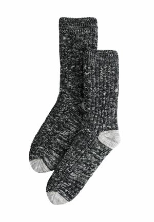 Schwarze und graue gestrickte Socken mit gerippter Textur und hellgrauen Akzenten an Zehen und Ferse. Bequemes, dickes Material für Wärme.