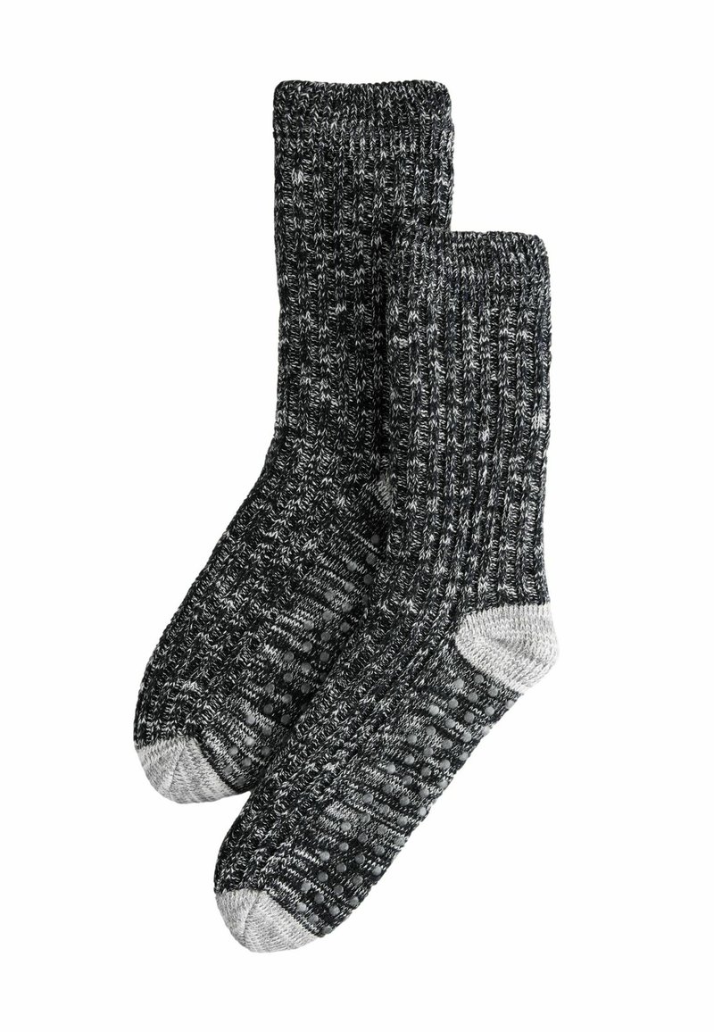 Schwarze und graue gestrickte Socken mit gerippter Textur und hellgrauen Akzenten an Zehen und Ferse. Bequemes, dickes Material für Wärme.