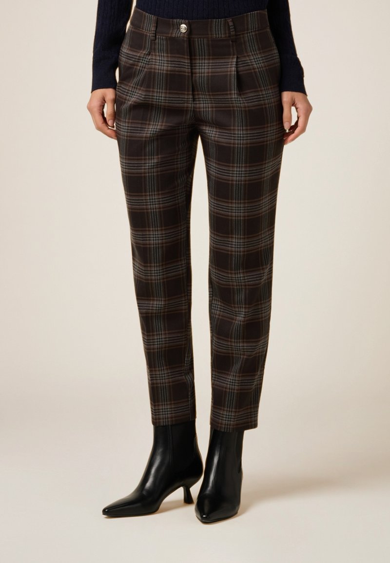 Skræddersyede brune ternede bukser med en blanding af mørke og lyse plaid-mønstre. Har en tilpasset talje og et smalt ben-design, kombineret med sorte hæle.