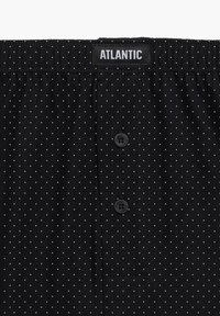 Czarne bokserki w biały wzór w kropki, elastyczny pas z napisem "ATLANTIC" oraz dwa guziki z przodu do zapięcia.