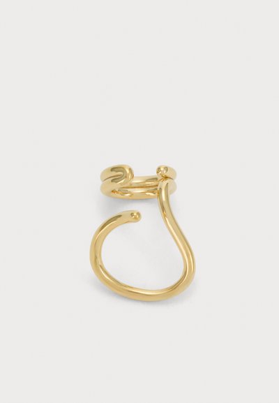 Une bague manchette ouverte en or poli, composée de bandes incurvées aux extrémités arrondies, présentée sur un fond clair uni.