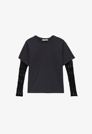 Camiseta negra de manga corta superpuesta sobre mangas largas de red negra con cuello redondo sobre fondo blanco.