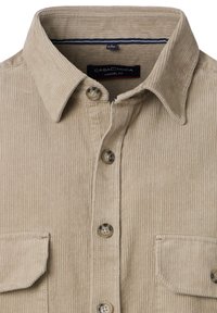 Beige corduroy casual fit shirt met knoopsluiting aan de voorkant, puntige kraag en klepzakken aan beide zijden.