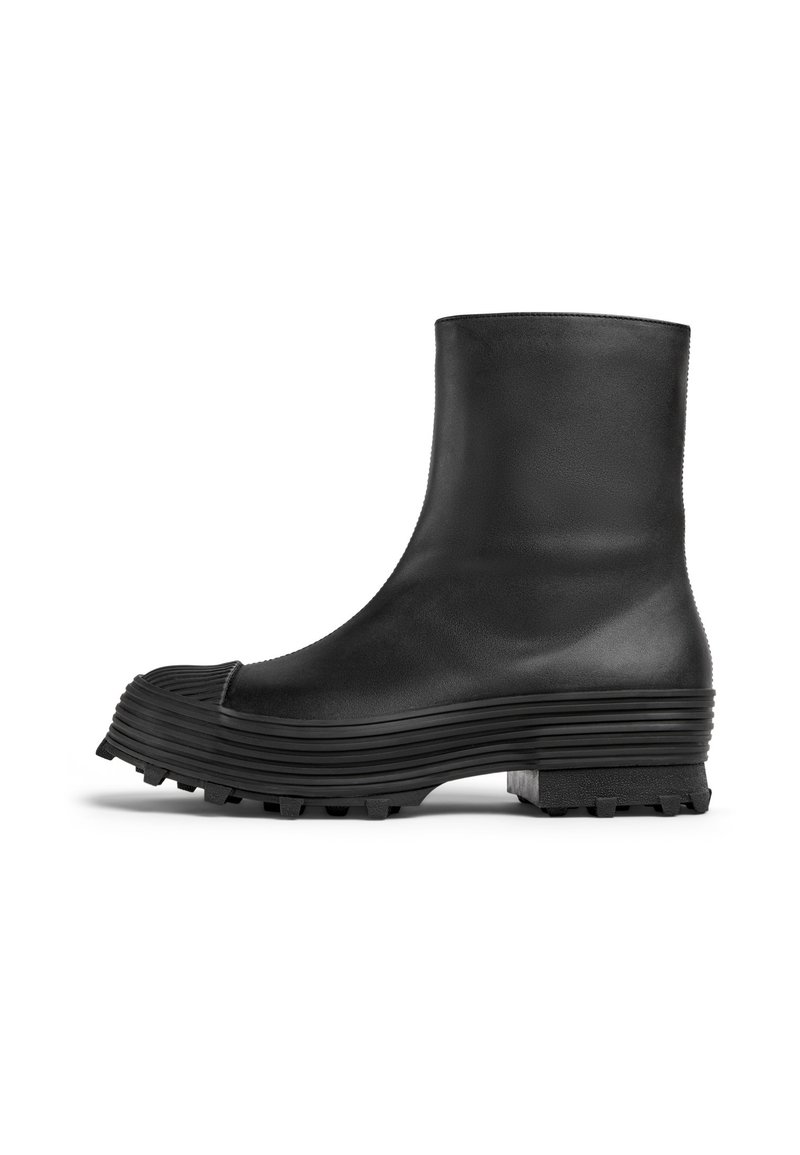 Stivaletto nero in pelle liscia con suola rigida e scanalata e punta arrotondata, caratterizzato da una finitura testurizzata e battistrada resistente.