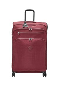 Red textile suitcase with a retractable handle, two front zippered pockets, and four wheels. Features a logo and a decorative charm.