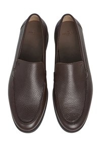 Mörkbruna läderslip-on skor med pebblad textur, rund tå och infälld detalj. Varumärket syns inuti nära hälen.