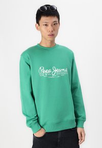 Sudadera verde con mangas largas, puños acanalados, cuello redondo y estampado en blanco del logo "Pepe Jeans" en la parte delantera. Tejido de mezcla de algodón.
