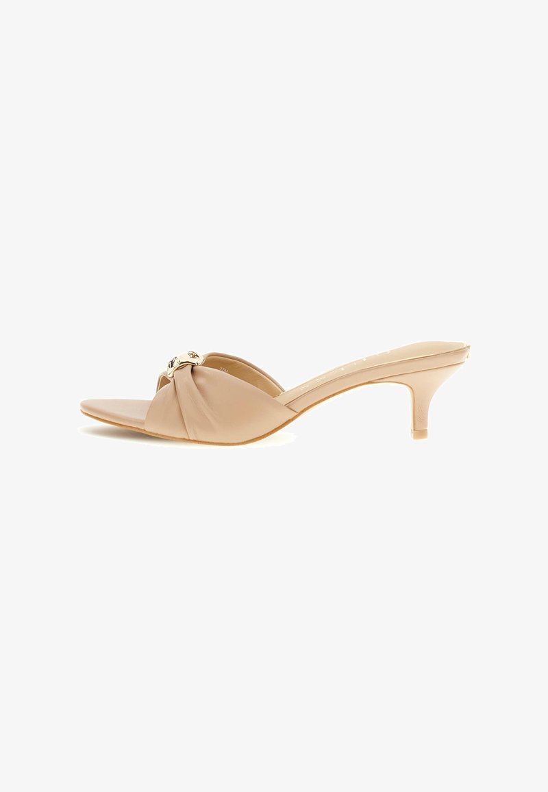 Mule beige à bout ouvert avec bride supérieure torsadée et petit talon kitten, ornée d’un accent décoratif doré à l’avant.