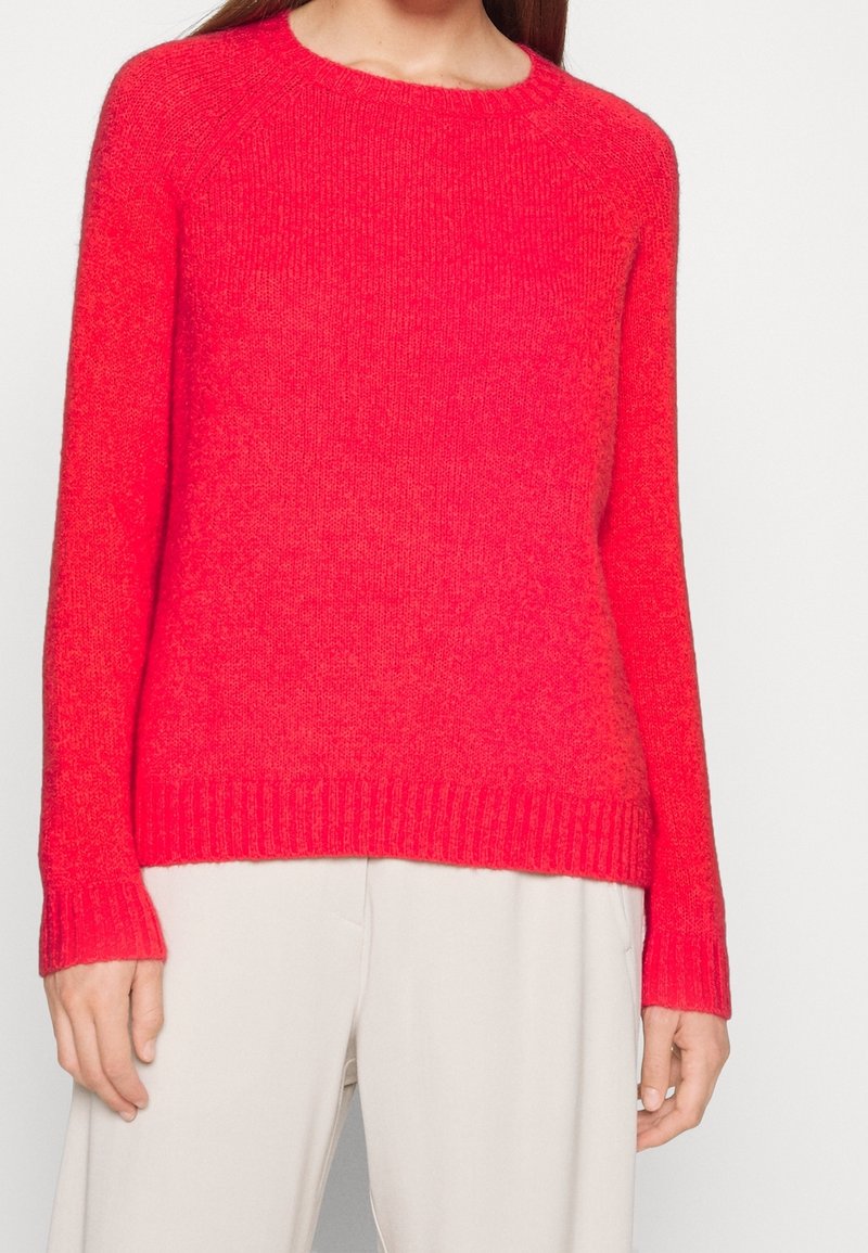 Gebreide trui in levendig roze, met een ronde halslijn, lange mouwen, ribgebreide manchetten en zoom, gemaakt van een zachte, gestructureerde stof.