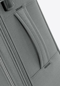 Šedý látkový kufr s diagonální texturou, vybavený horním madlem a detaily zipu. Odolný materiál a funkční designové prvky.
