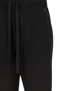 Zwarte joggers met een zachte textuur, voorzien van een brede tailleband, trekkoorden en zijzakken. Eenvoudig, minimalistisch ontwerp.