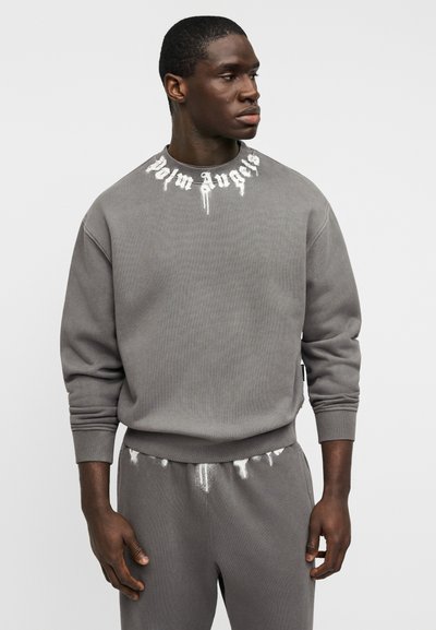 Γκρι φούτερ από υφασμάτινο ύφασμα με υφή, με λαιμόκοψη crew και λευκό λογότυπο «Palm Angels» στο γιακά, συνδυασμένο με αντίστοιχο παντελόνι φόρμας.