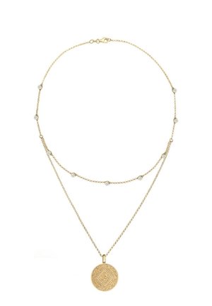 Delicate gold double-layered necklace with small crystal accents on upper chain and round engraved pendant on longer chain.
