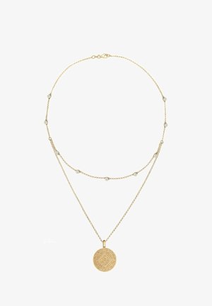 Collier délicat en or à double couche avec de petits accents en cristal sur la chaîne supérieure et un pendentif rond gravé sur la chaîne plus longue.