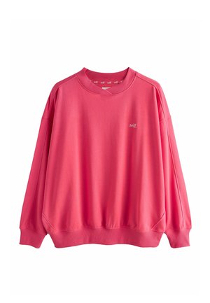 Pink crewneck sweatshirt with ribbed cuffs and hem, featuring small white "self." text on the left chest and inside collar.