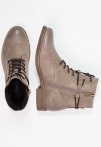 Botines taupe con cremallera lateral, cordones marrón oscuro, tacón bajo apilado y puntera redondeada, mostrados desde vistas superiores y laterales.