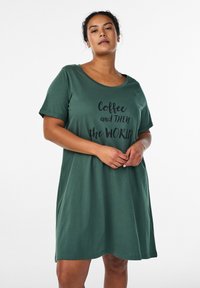 Green T-shirt dress in soft fabric, featuring short sleeves, a round neckline, and a printed phrase in black on the front.