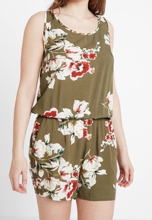 Combinaison kaki sans manches avec imprimé floral blanc et rouge, taille élastique, portée par une personne debout devant un fond uni.