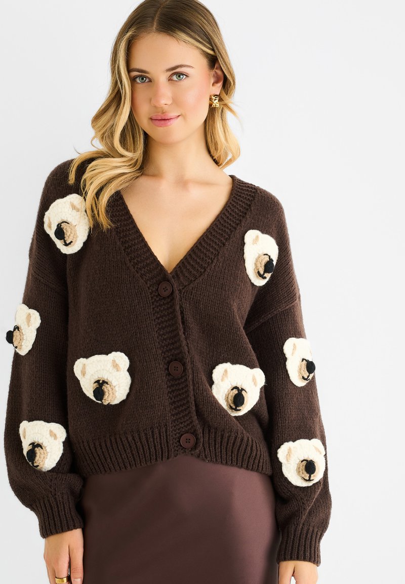 Brown knitted cardigan featuring cream-colored bear appliqués on the front, long sleeves, and a deep V-neckline with three buttons.