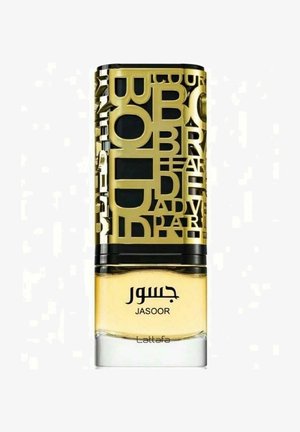 Hajuutepullon läpinäkyvä lasipohja, keltainen neste ja kultainen G-kuvioitu kansi, jossa on näyttävä arabialainen ja englanninkielinen teksti.