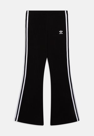 Černé rozšířené kalhoty s dvěma vertikálními bílými pruhy po stranách. Na levém stehně se nachází bílé logo Adidas. Měkký materiál.