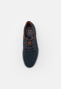 Zapato casual azul marino con detalles en naranja, cordones y plantilla con marca, visto desde arriba sobre fondo blanco.