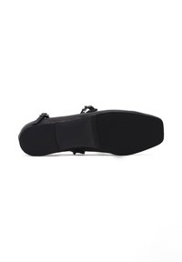 Scarpa nera piatta con tomaia in pelle liscia, design minimalista, cinturini regolabili e suola in gomma texturizzata per la presa.