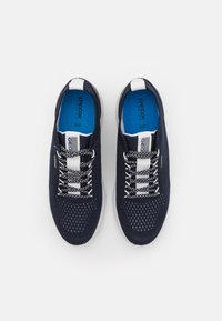 Marinblå mesh-sneakers med vita och grå detaljer. Har runda snören och perforerad design för ventilation. Blå innersulor synliga.