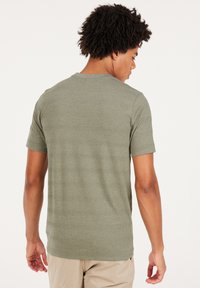 Groene t-shirt met korte mouwen en een subtiele gestreepte textuur, gemaakt van zachte stof. Beschikt over een klassieke ronde halslijn en een ontspannen pasvorm.