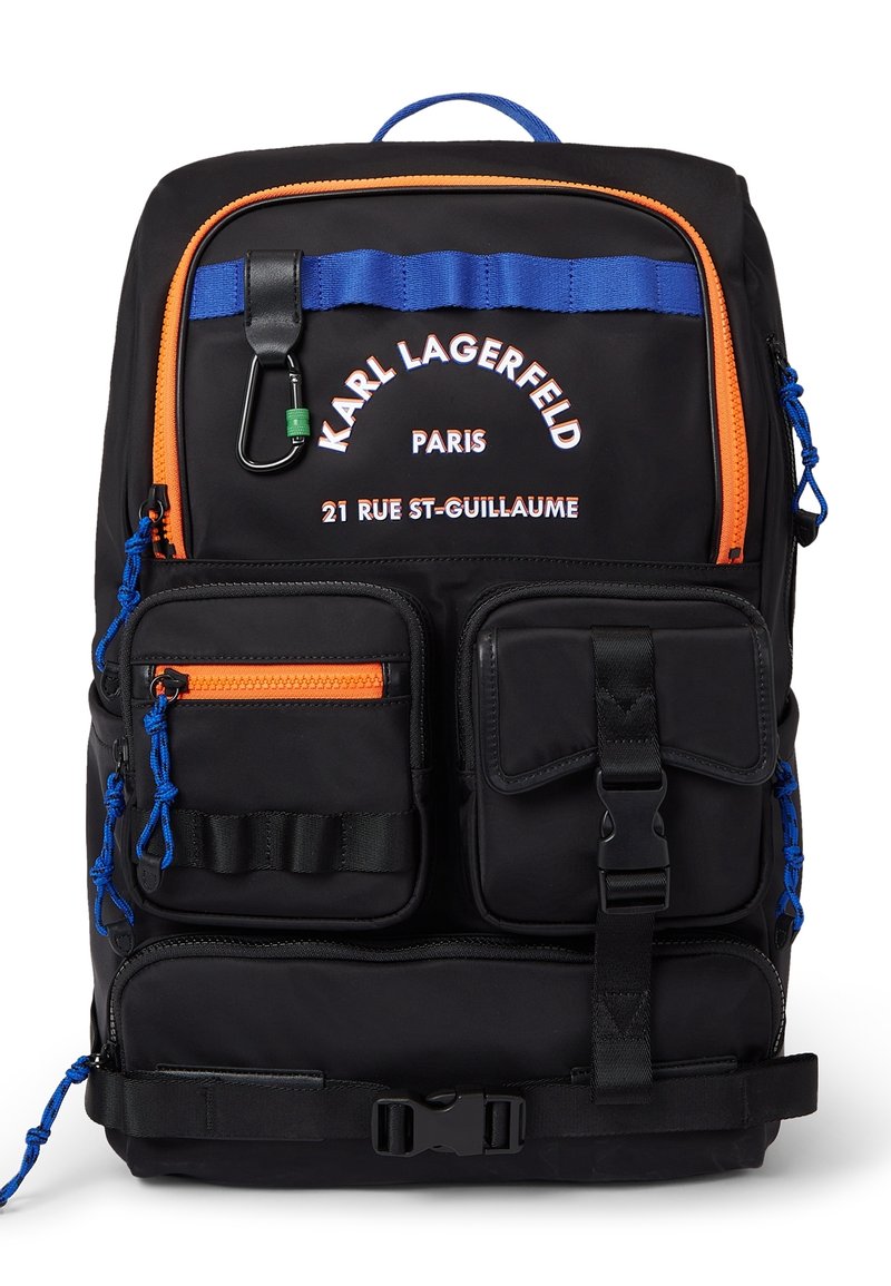 Mustan nailonisen reppun, jossa on sinisiä ja oransseja yksityiskohtia, useita etutaskuja, säädettävät hihnat ja ylhäällä oleva kahva. Logo painettuna valkoisena.