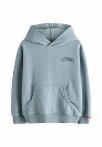 Gaiši zilā kapuce no mīksta auduma ar priekšējo kabatu un ribinātām aprocēm. Uz krūtīm ir izšūts "SUPERDRY" logo.