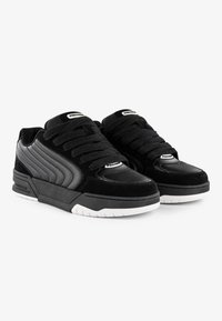 Black sneakers with a textured suede and smooth leather upper, featuring prominent laces, white rubber outsole, and branded accents.