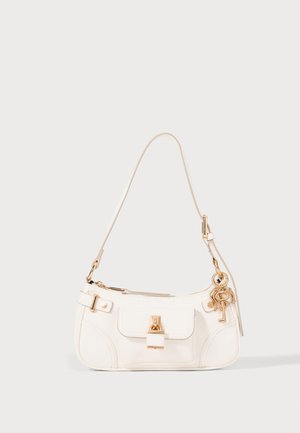 White leather handbag with a curved design, gold hardware, a front flap pocket, and a key charm accent. Features a detachable shoulder strap.