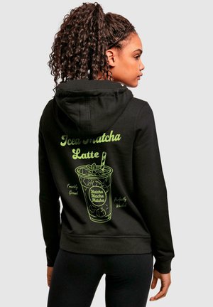 Black hoodie with a green graphic of an iced matcha latte on the back, featuring text and illustrations of the drink's details.