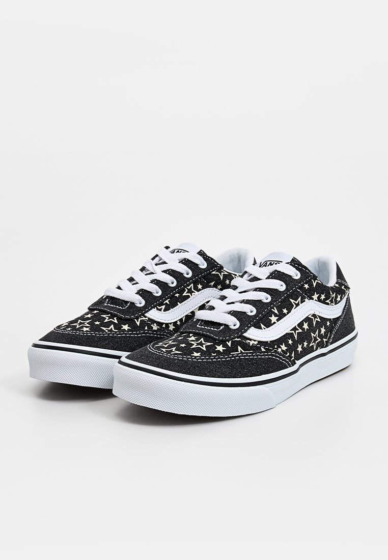 Zapatillas de lona negras con un patrón de estrellas, cordones blancos y acentos, con una suela de goma blanca y un diseño clásico.
