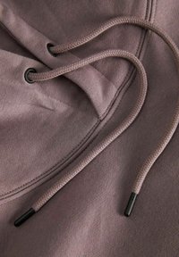 Mauve hoodie featuring a drawstring with black plastic tips and reinforced grommets, made from soft, textured fabric.