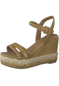 Braune Leder-Wedge-Sandale mit geflochtenen Riemen und Knöchelverschluss. Mit einer gewebten Jute-Plattform und strukturiertem Sohlen.