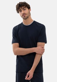 Mörkblå kortärmad t-shirt i mjukt tyg, med en kontrasterande ljusgrå rund halsringning. Avslappnad passform med sömnadsdetaljer vid fållarna.