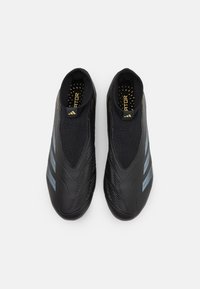 Scarpe da atletica nere con un design elegante, realizzate in materiale sintetico testurizzato. Presentano strisce grigie lungo i lati e una calzata imbottita e slip-on.