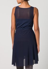 Robe marine avec un corsage ajusté et une jupe évasée. Présente un panneau en maille à l'arrière, un matériau doux et un détail de ceinture au niveau de la taille.