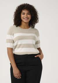 Beige en witte gestreepte korte mouwen trui met een ronde halslijn, gecombineerd met zwarte broek; de textuur lijkt zacht en lichtgewicht.