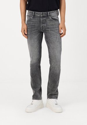 Gray denim jeans with a slim fit, faded texture, five-pocket design, and a subtle wash effect, paired with white sneakers.