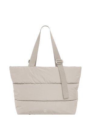 Beige polstret tote-taske med to håndtag og en justerbar skulderrem, med en lille "Got Bag"-logo nær bunden i midten.