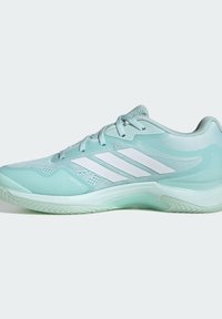 Chaussure de sport basse bleu clair avec trois bandes blanches Adidas, fermeture à lacets et semelle texturée, conçue pour la performance sportive.