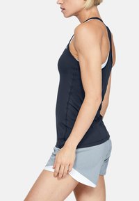 Marineblå tanktop med en tettsittende design og teksturert stoff, sammen med lysegrå treningsshorts som har en hvit detalj i kanten.