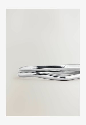 Brățară elegantă din metal cromat, cu un design neted și răsucit, având o suprafață reflectantă. Nu sunt vizibile modele sau accente distincte.