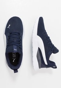 Marineblauwe mesh sneakers met witte accenten, gestructureerde zool, ronde neus en vetersluiting. Voorzien van een treklabel en logo op de tong.